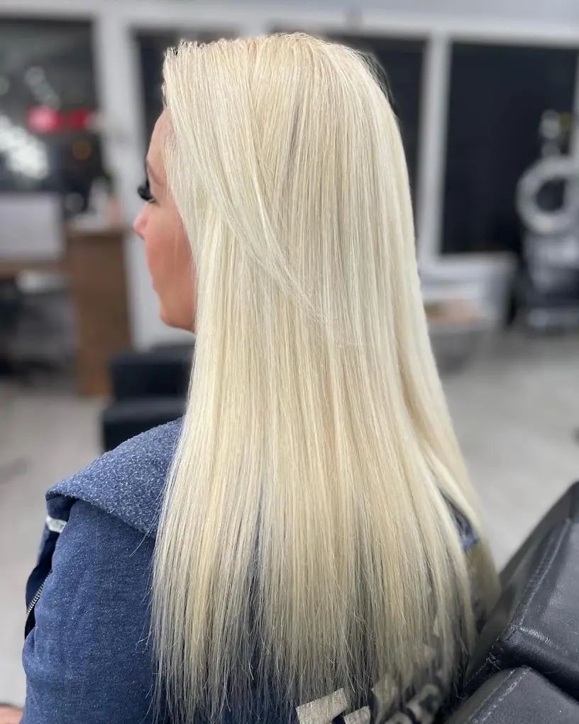 Home 7 A woman with long blonde hair extensions, smiling and showing off her new look.