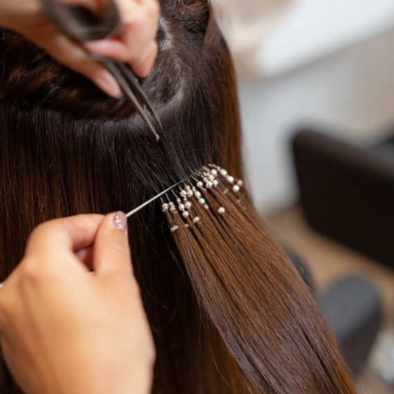 I-Tip Hair Extensions 8 Close-up of professional installing I-tip hair extensions with microbeads.